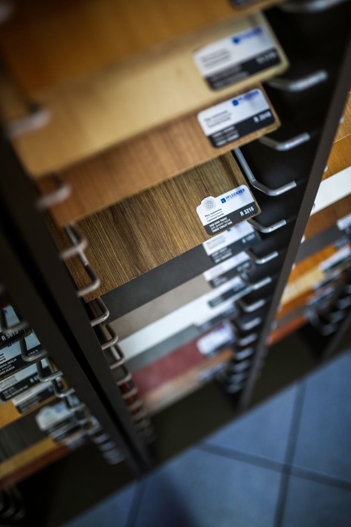 services-04 Close-up of various laminated wood veneer samples in a showroom display rack.
